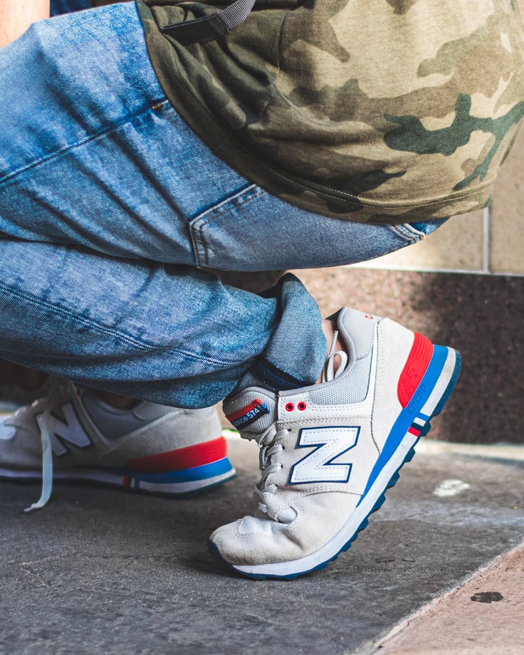 Person Wearing White-and-blue New Balance Sneakers